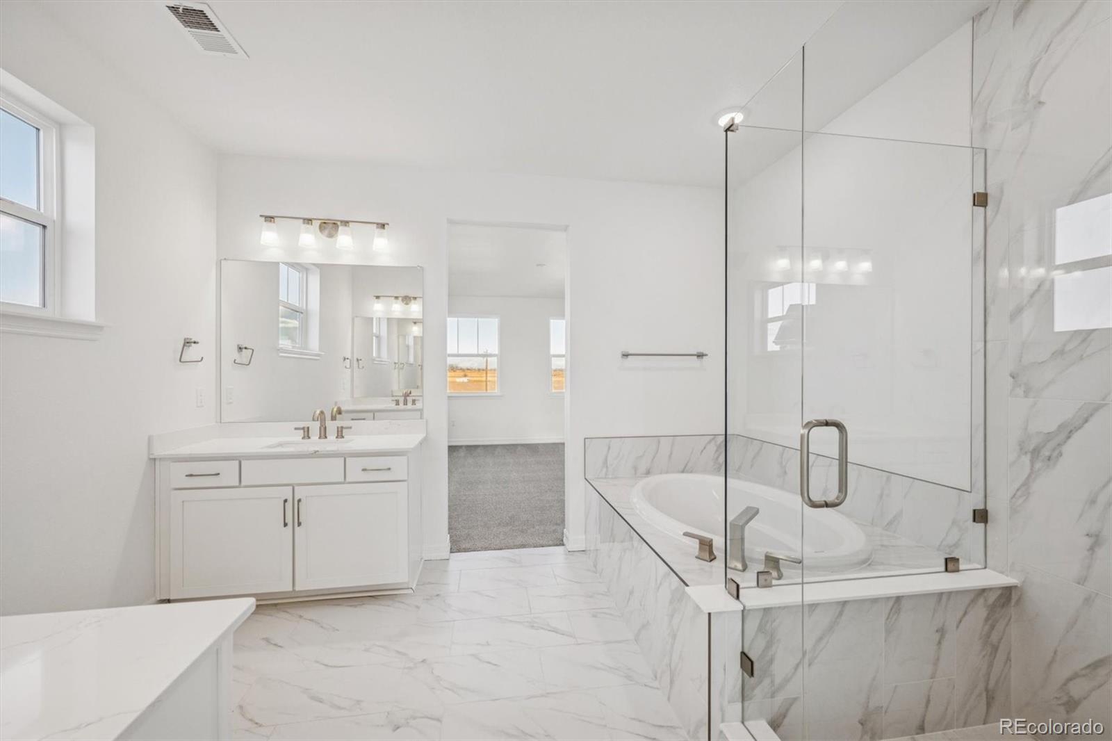 1162 Weller Street Timnath, CO 80547 - Photo 17 of 29 a bathroom with a granite countertop sink a toilet a glass door shower and mirror