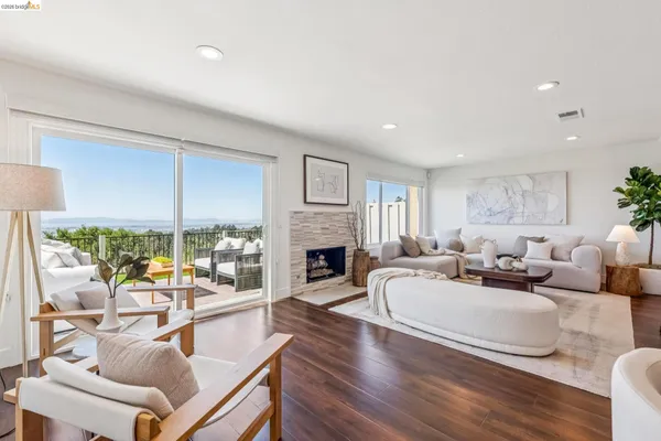 a living room with furniture fireplace and a large window