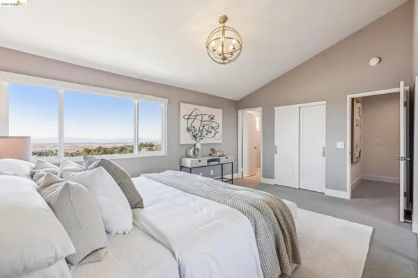 a spacious bedroom with a bed and a chandelier