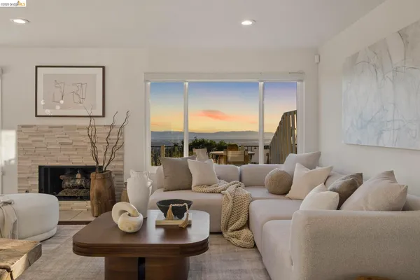 a living room with furniture a fireplace and kitchen view