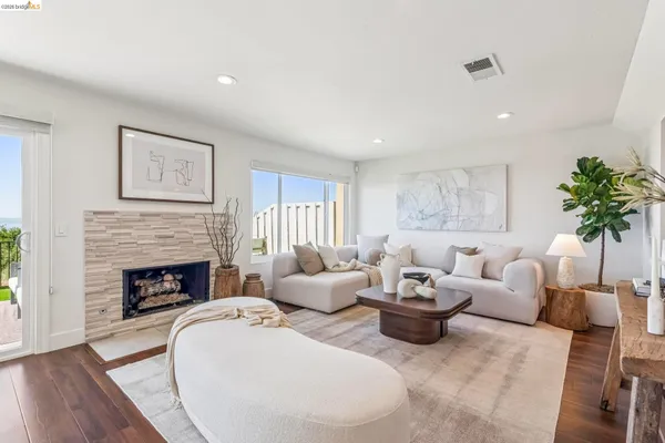 a living room with furniture a fireplace and a potted plant