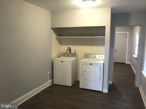 a utility room with wooden floor washer and dryer