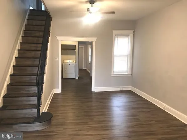 a view of an entryway with wooden floor and white walls