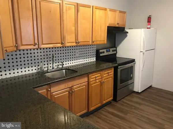 a kitchen with stainless steel appliances granite countertop a refrigerator and a stove