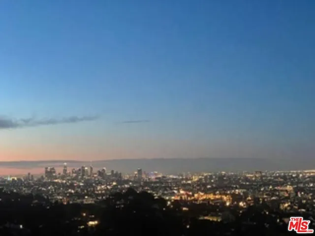 an aerial view of house with yard and mountain view in back