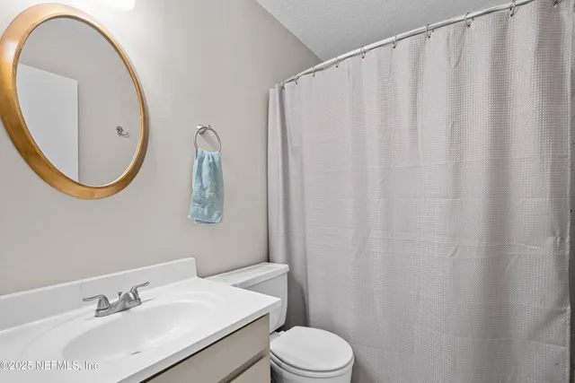 a bathroom with a sink vanity mirror and toilet