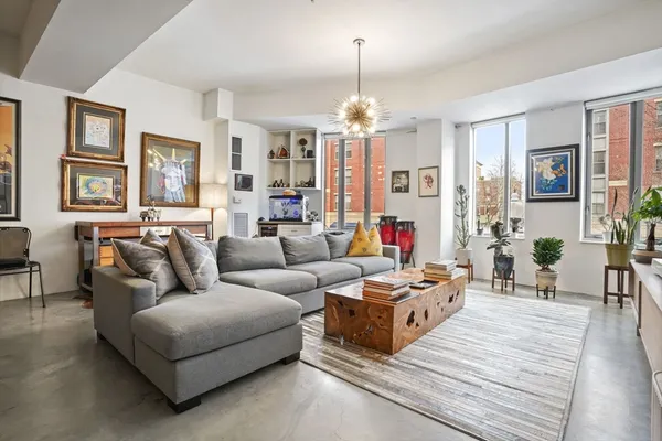 a living room with furniture chandelier and a table