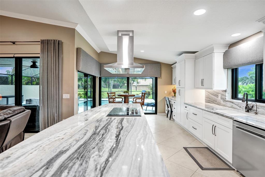 21357 Bridgeview Drive Boca Raton, FL 33428 - Photo 21 of 54 a large kitchen with kitchen island a large window cabinets a sink and stainless steel appliances