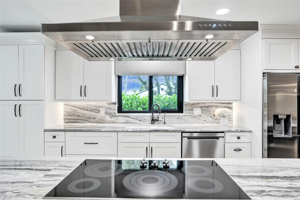 21357 Bridgeview Drive Boca Raton, FL 33428 - Photo 27 of 54 a kitchen with kitchen island granite countertop a sink stove and cabinets