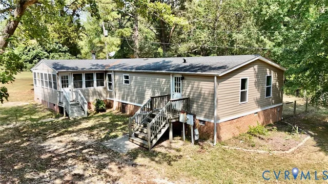 a view of a house with a yard and large tree