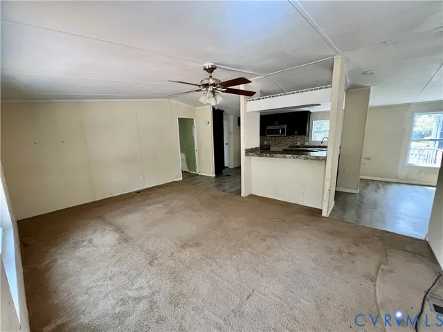 a view of a livingroom with a flat screen tv wooden floor and a ceiling fan