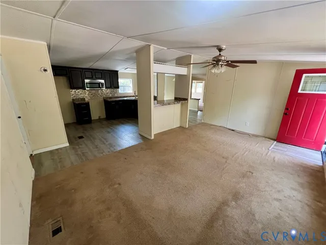 a view of a livingroom with furniture and a kitchen