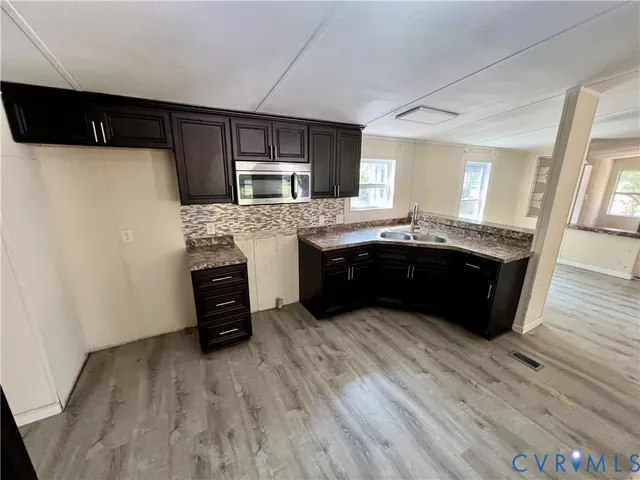 a kitchen with granite countertop a sink and a stove top oven