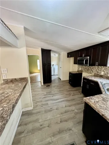 a large white kitchen with kitchen island granite countertop a stove and a sink