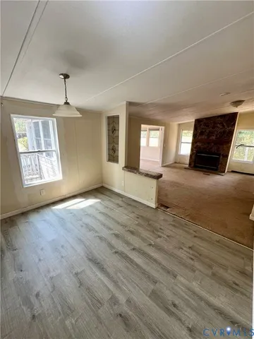 an empty room with windows and fireplace