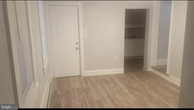 a view of an empty room with wooden floor