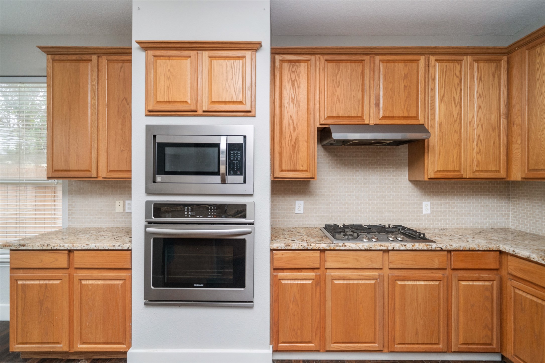 11534 Alpena Lane Houston, TX 77095 - Photo 7 of 28 a kitchen with granite countertop wood cabinets stainless steel appliances and a window