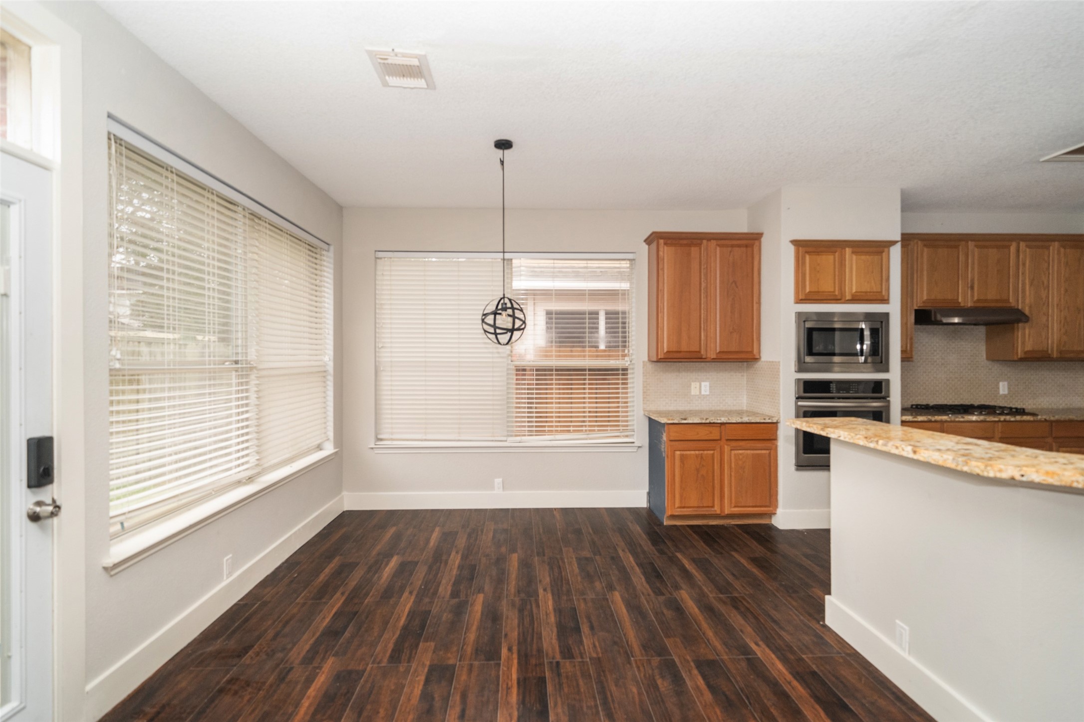 11534 Alpena Lane Houston, TX 77095 - Photo 8 of 28 a kitchen with stainless steel appliances wooden floors and wooden cabinets