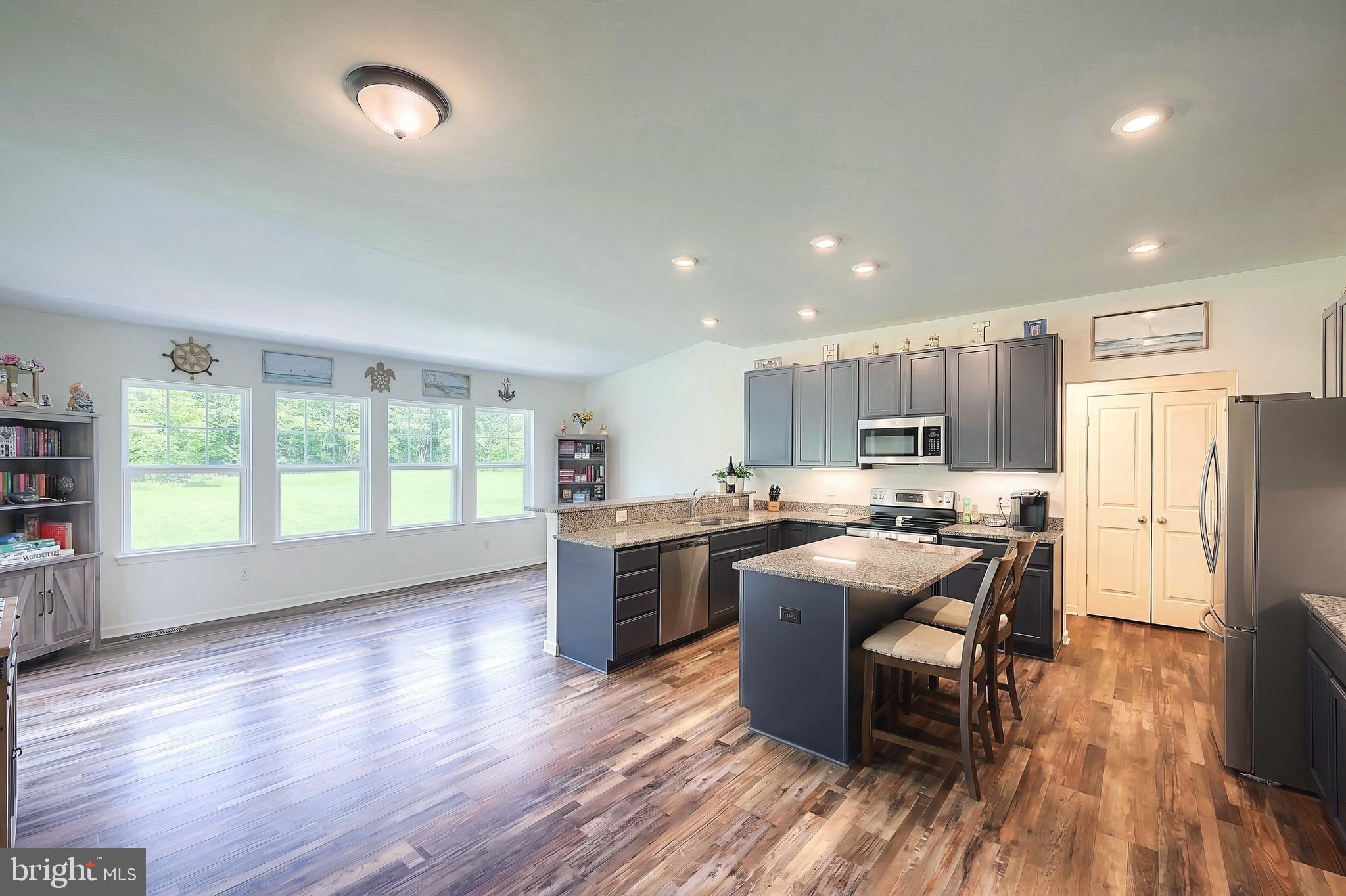 2741 Cold Springs Road Orrtanna, PA 17353 - Photo 20 of 52 a kitchen with stainless steel appliances granite countertop a refrigerator a sink dishwasher a stove top oven a dining table and chairs with wooden floor