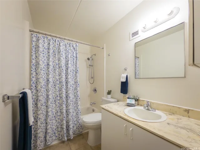 a bathroom with a granite countertop sink toilet and mirror
