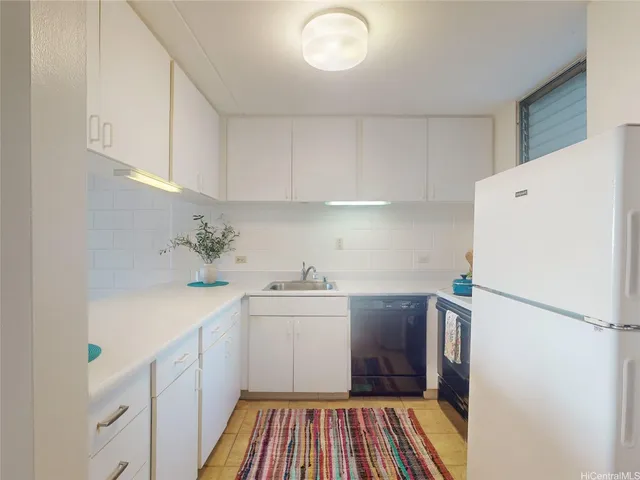 a kitchen with a sink a refrigerator and cabinets