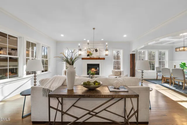 a large kitchen with kitchen island a island a sink a stove and a dining table with wooden floor