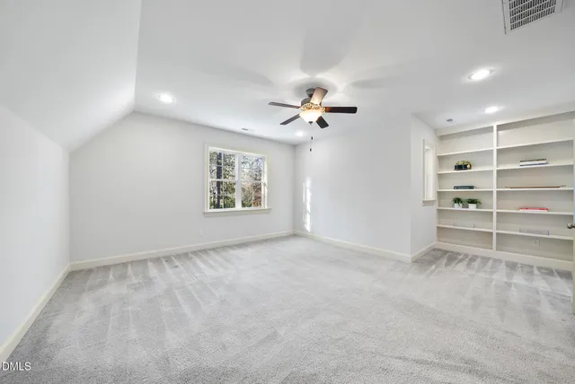 an empty room with a window and a fan