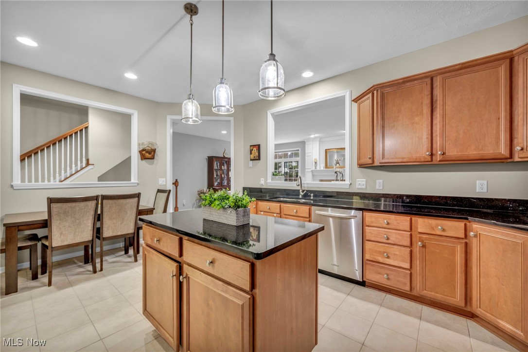 30257 Center Ridge Road Westlake, OH 44145 - Photo 15 of 42 Kitchen with brown cabinets, dishwasher, dark stone countertops, a center island, and pendant lighting