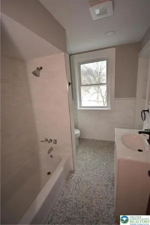 a bathroom with a tub sink and window