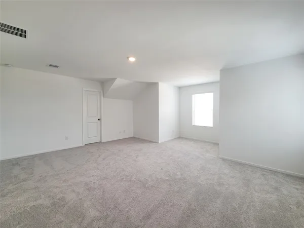 a view of an empty room with a window and closet area