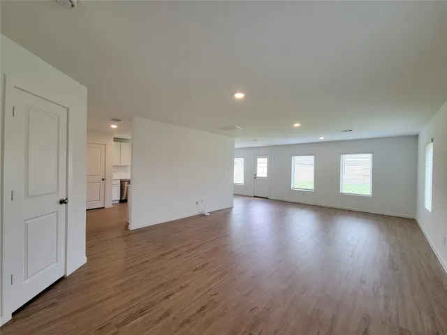 a view of a big room with wooden floor and windows