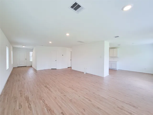 a view of empty room with wooden floor and window