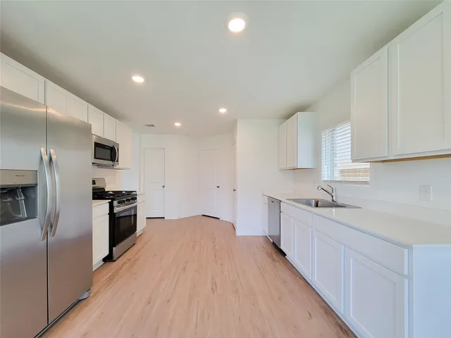 a kitchen with stainless steel appliances granite countertop a sink stove and refrigerator