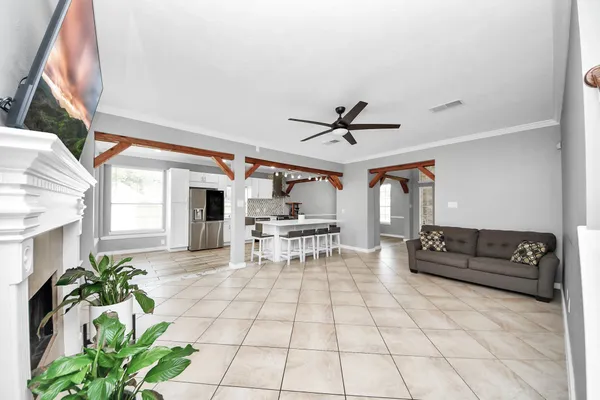 a view of a livingroom with wooden floor and a ceiling fan