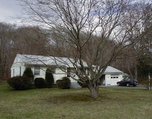 a white house that has a tree in front of it