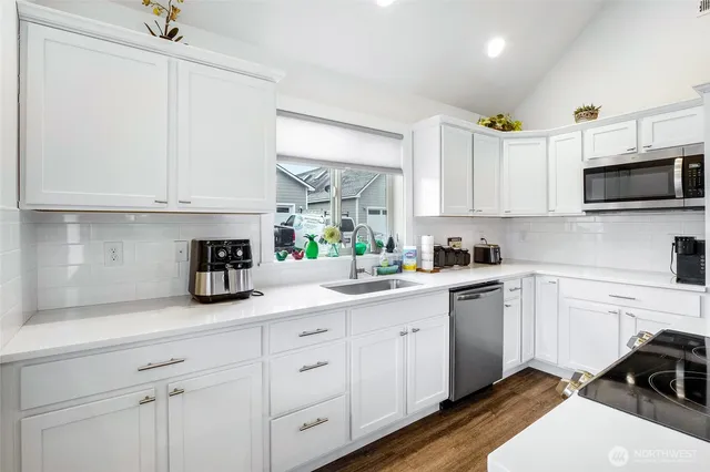 a kitchen with granite countertop white cabinets and white appliances