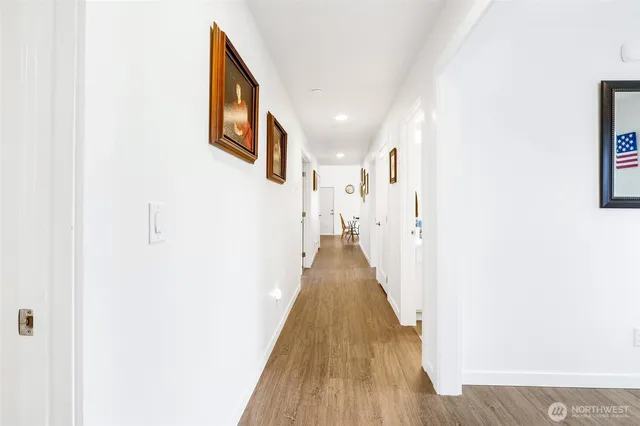 a view of a hallway with wooden floor and staircase