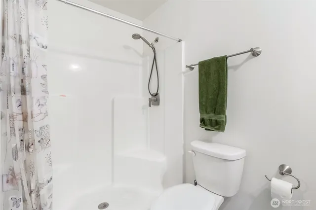 a bathroom with a shower a toilet and a shower