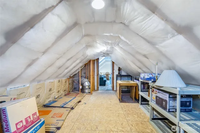 a room with lots of white furniture and a chandelier