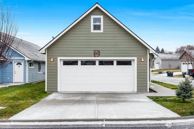 a view of a white house with a yard and garage