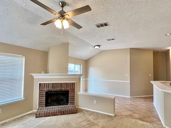 a living room with a fireplace and a ceiling fan