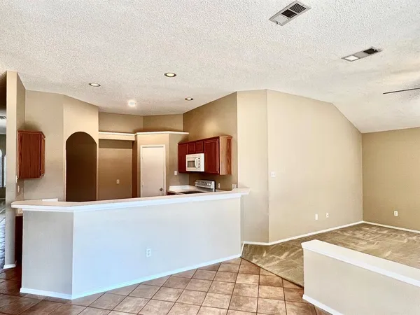 a large white kitchen with a sink and a refrigerator
