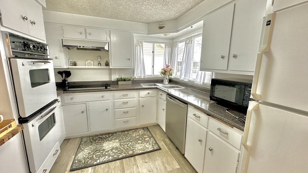 294 Killdeer Road Webster, MA 01570 - Photo 20 of 42 a kitchen with stainless steel appliances granite countertop a refrigerator a stove top oven a sink and dishwasher