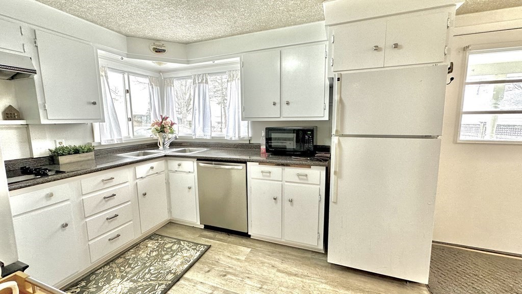 294 Killdeer Road Webster, MA 01570 - Photo 25 of 42 a kitchen with white cabinets and white appliances