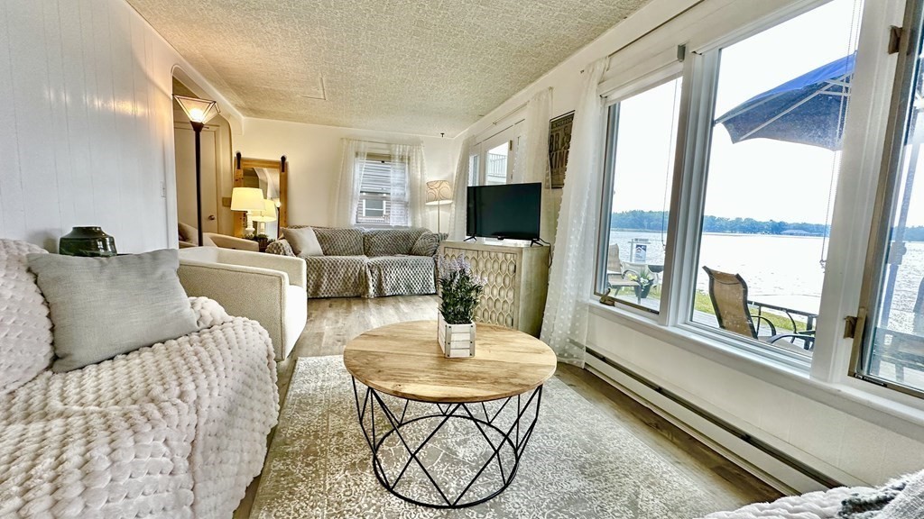 294 Killdeer Road Webster, MA 01570 - Photo 8 of 42 a living room with furniture a flat screen tv and a large window