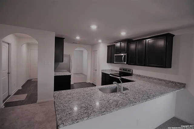 a kitchen with stainless steel appliances granite countertop a sink stove and refrigerator