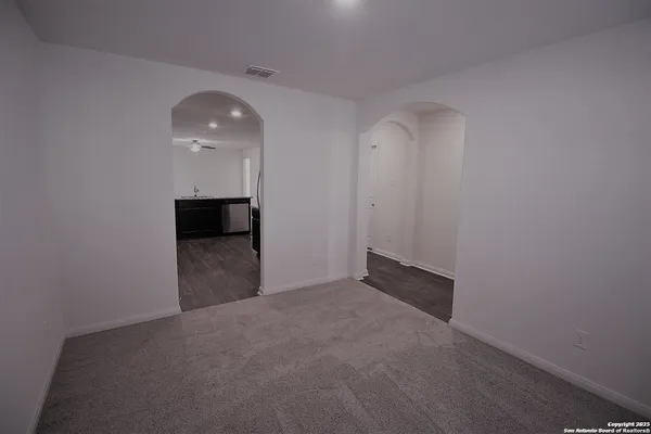 a view of an empty room with a kitchen