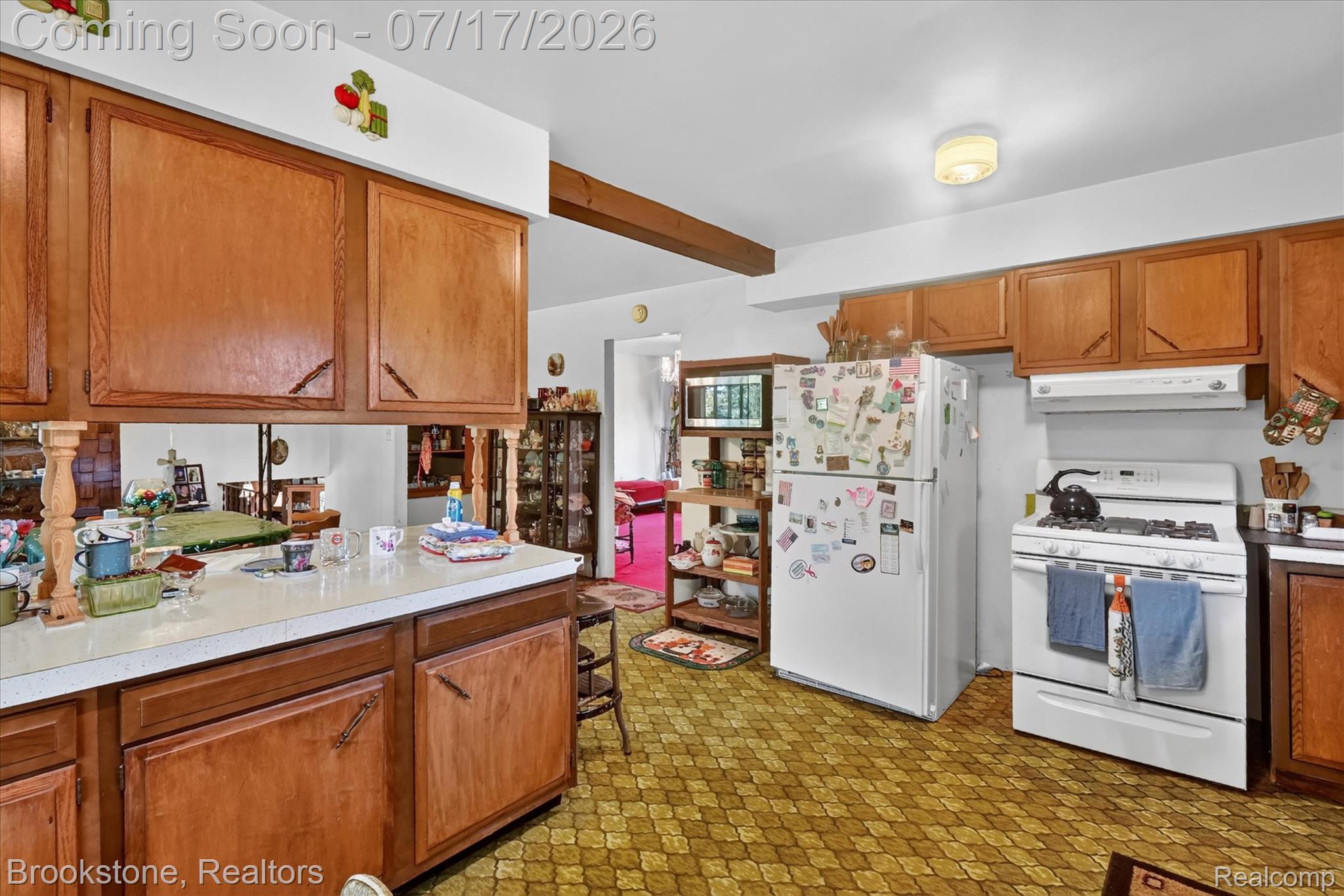 22025 Lakefield Road Merrill, MI 48637 - Photo 14 of 47 Kitchen featuring wood cabinetry, white countertops, a white gas range with overhead ventilation, and a white refrigerator