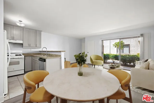 a kitchen with stainless steel appliances a dining table chairs and wooden floor