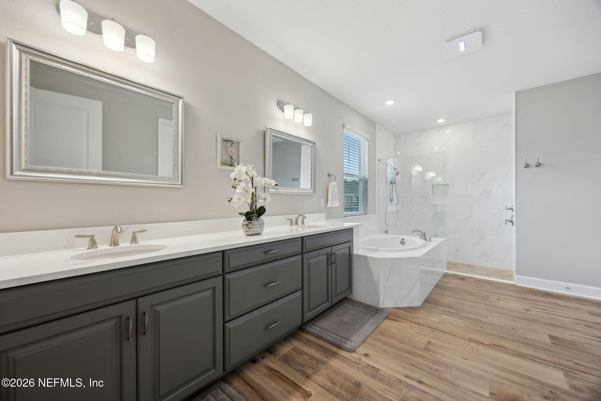 92503 Shipton Lane Fernandina Beach, FL 32034 - Photo 18 of 32 a bathroom with a double vanity sink a mirror and a bathtub
